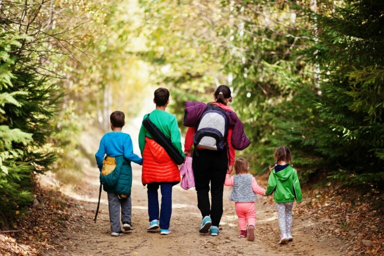 Una famiglia passeggia in un sentiero nel bosco