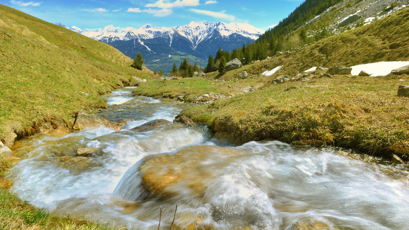 Un ruscello di montagna d'estate con vista delle Dolomiti